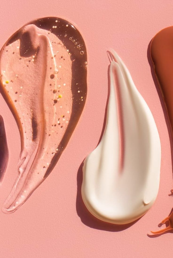 Swirl of creamy skincare textures on a pink background