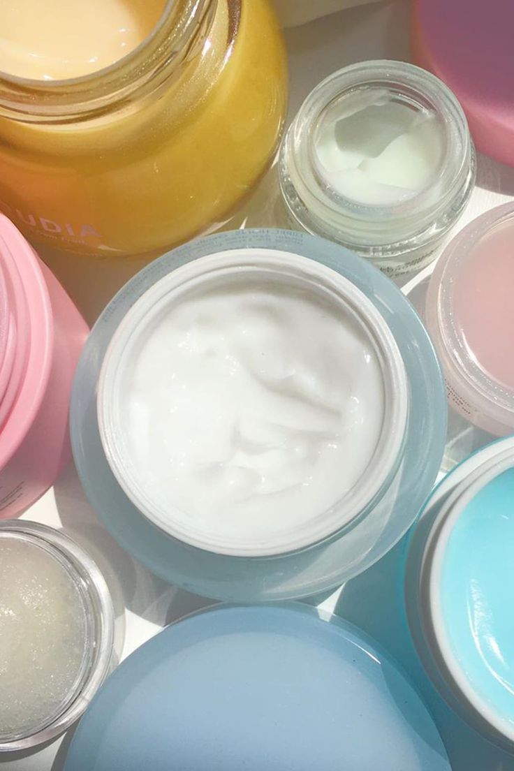 Open jars of pastel moisturising creams